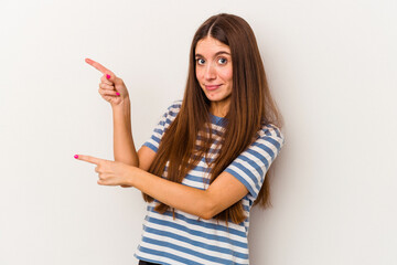 Young caucasian woman isolated on white background shocked pointing with index fingers to a copy space.
