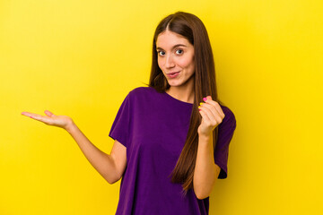 Young caucasian woman isolated on yellow background showing that she has no money.