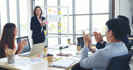 Group of business people meeting in conference room. Asian businessman speech, present teamwork partnership. Happy business people meeting present graph chart investment, business data in meeting room