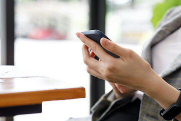 image of a businesswoman hand using her smartphone at an office meeting,blur background.