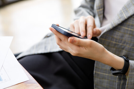 image of a businesswoman hand using her smartphone at an office meeting,blur background.