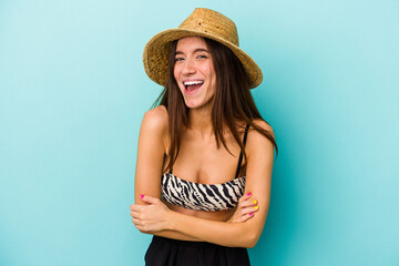 Young caucasian woman going to the beach wearing bikini isolated on blue background laughing and having fun.