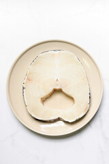 Snow fish on plate for delicious good meal. Snow fish are found in the deep ocean, thick flake and melt-in-your-mouth texture. Isolated on white marble table background.