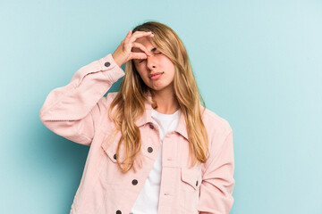 Young caucasian blonde woman isolated on blue background  having a head ache, touching front of the face.