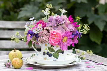 Obraz na płótnie Canvas Blumenstrauß mit pink Sommerblumen in Tasse als florale Dekoration