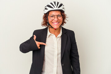 Middle age latin business woman wearing a bike helmet isolated on white background person pointing by hand to a shirt copy space, proud and confident