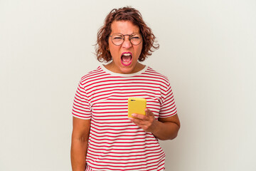 Middle age latin woman isolated on white background screaming very angry and aggressive.