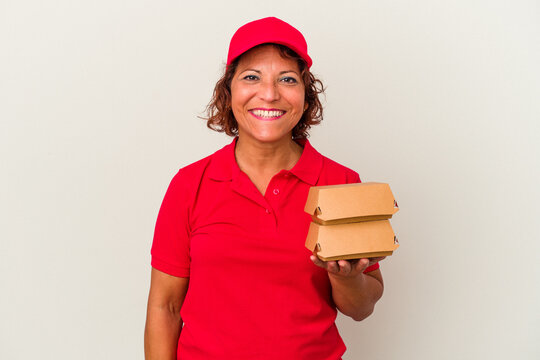 Middle age delivery woman taking burguers isolated on white background happy, smiling and cheerful.