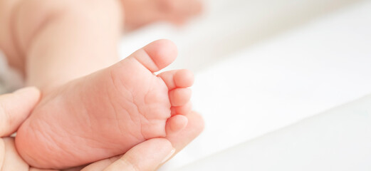 Tiny baby feet on white blanket. Banner. Copy space