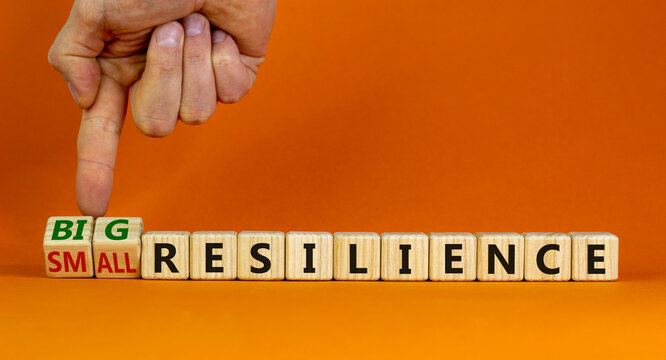 Big Or Small Resilience Symbol. Businessman Turns Wooden Cubes, Changes Words Small Resilience To Big Resilience. Beautiful Orange Background, Copy Space. Business, Big Or Small Resilience Concept.