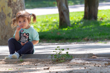 Little girl with pigtails eating lollipop