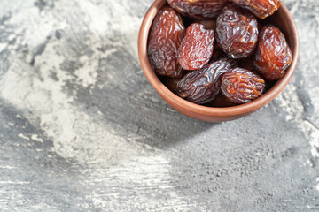 Bowl with dry dates. Top view heap. Healthy sweet snacks. Islamic turkish appetizer. Delicious fresh fruit. Bright background