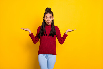 Photo of impressed funny dark skin woman dressed red sweater holding arms empty space isolated yellow color background