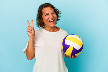 Middle age latin woman playing volleyball isolated on blue background showing number two with fingers.