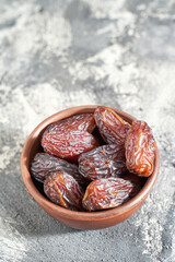 Bowl with dry dates. Top view heap. Healthy sweet snacks. Islamic turkish appetizer. Delicious fresh fruit. Bright background