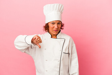 Middle age latin woman isolated on pink background showing a dislike gesture, thumbs down. Disagreement concept.
