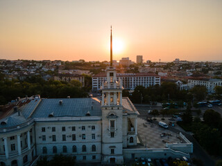 an old chapel in the summer city square at sunset from a bird's eye view.