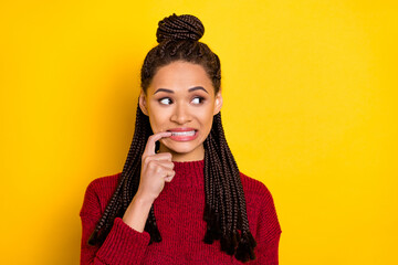 Photo of unhappy guilty dark skin woman dressed red sweater biting finger looking empty space...