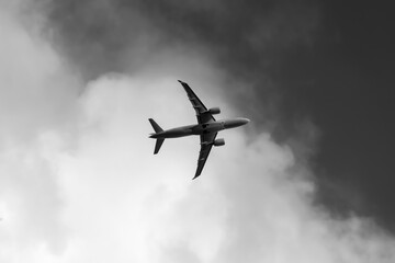 Flugzeug Himmel von unten Graustufen schwarz weiß Umriss Wolke Sonne Tragfläche Start Landung Fliegen Flugplatz Airport Jet Reise Verbindung Abflug Luftverkehr Destination Silhouette Urlaub Kontur 