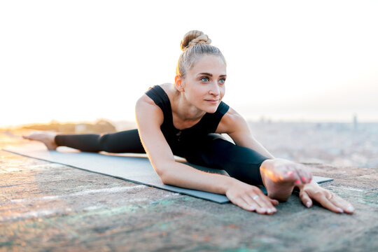 Flexible woman in Wide Splits pose on sports mat