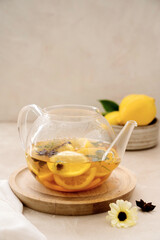Delicious fresh warm tea with lemon, orange fruit, cinnamo and fresh mint. Herbal healthy beverage in glass teapot