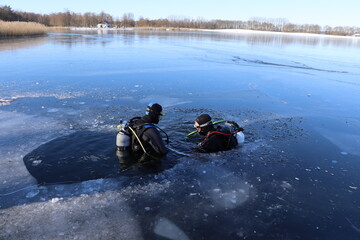 Fototapeta na wymiar Scuba diving under the ice, preparing, mask, snorkel, diving gear, cold winter. Diving course 