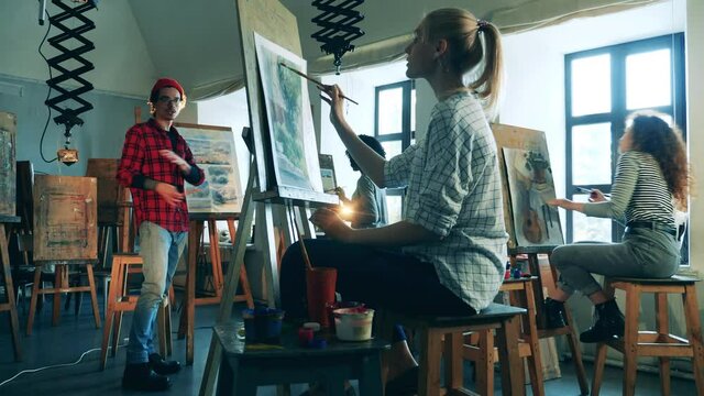 Group of women are having an art class with a male painter
