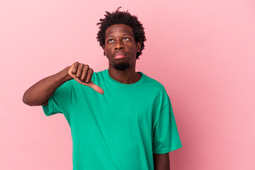 Young african american man isolated on pink background showing a dislike gesture, thumbs down....