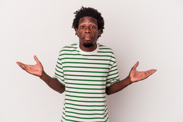Young african american man isolated on white background  doubting and shrugging shoulders in...