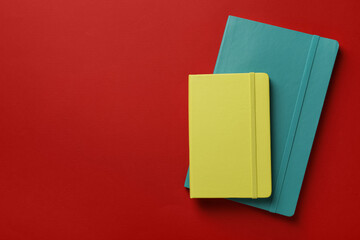New stylish planners on red background, top view. Space for text