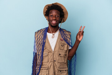 Young african american fisherman holding a net isolated on blue background joyful and carefree...
