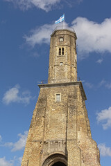 Tour du Guet watchtower to protect Calais from viking invasions in the middle ages, low angle view on a blue sky with soft clouds 