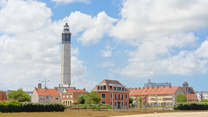 Calais lighthouse or Phare de Calais, towering above the houses of a residential neighborhood in Calais, France on a sunny day with clear blue sky 