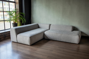 soft upholstered light sofa with modules in the interior with a panoramic window
