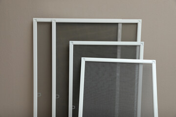 Set of window screens near beige wall