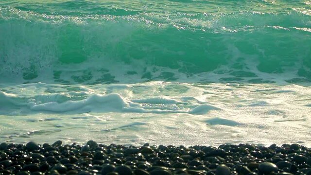 Waves forming and crashing onto a pebble beach. Filmed in the Philippines.