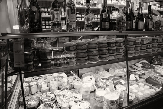 Jura, France - December 30, 2020: Food specialties shop interior. Local delicious sausages and ham, gourmet fois gras, wine, sweets and famous Comte and goat cheeses. Black white historic photo