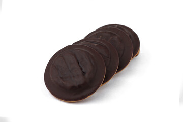 Pile of chocolate biscuit cookies with orange jam isolated on white background.