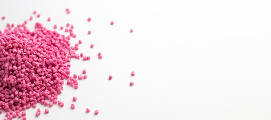 Pink granules of polypropylene or polyamide on a white background. Plastics and polymers industry....