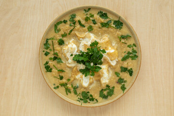 Rutabaga creamy soup with parsley garnish. Bowl top view.