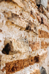 The wall of an old building made of red brick and stone.
