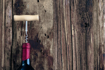 Wine bottle and wine opener on wood