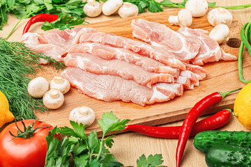 Steaks of fresh pork meat on a cutting board with mushrooms, dill, tomatoes, peppers, cucumbers. Recipe. Close-up.