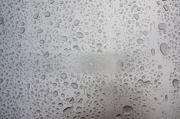 Abstract art texture background of raindrops on shiny brushed stainless steel metal surface of old retro vintage car. Drops of rainwater on a piece of polished industrial equipment
