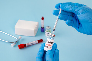 covid 19 delta Variant vaccine and test blood in hand on blue background. vaccination against...