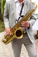 Saxophonist with saxophone prepares to perform at the holiday