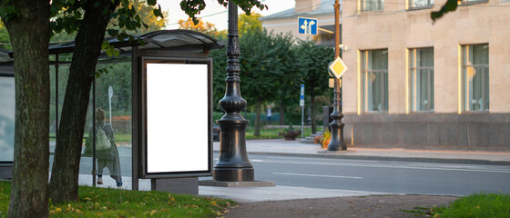 Vertical billboard screen at the bus stop. Mockup with advertising space. Against the background of...
