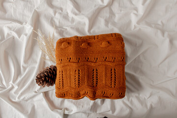 Women fashion composition. Warm winter female woolen knitted sweater on white bed sheet background. Modern clothes concept for magazine, blog, social media. Autumn composition.