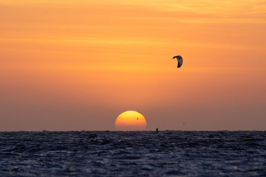 Sunset com kitsurf no mar. P&ocirc;r do sol na praia de Barra Grande, litoral do Piau&iacute;, nordeste brasileiro.