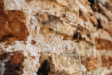 The wall of an old building made of red brick and stone. Brick wall close-up